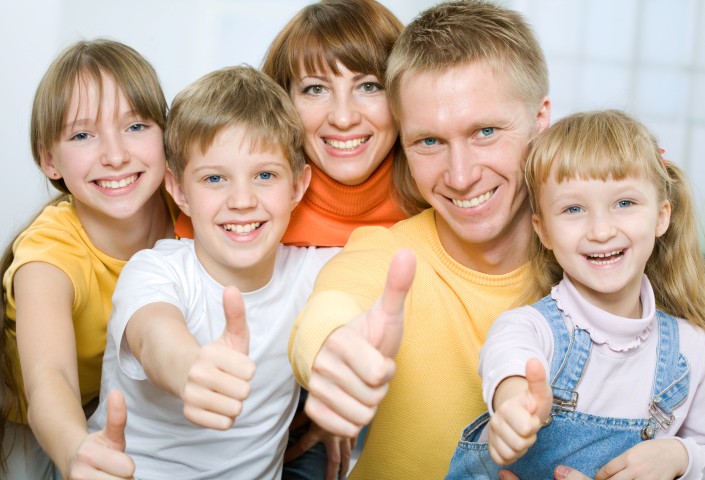 Cheerful family of five with their thumbs up